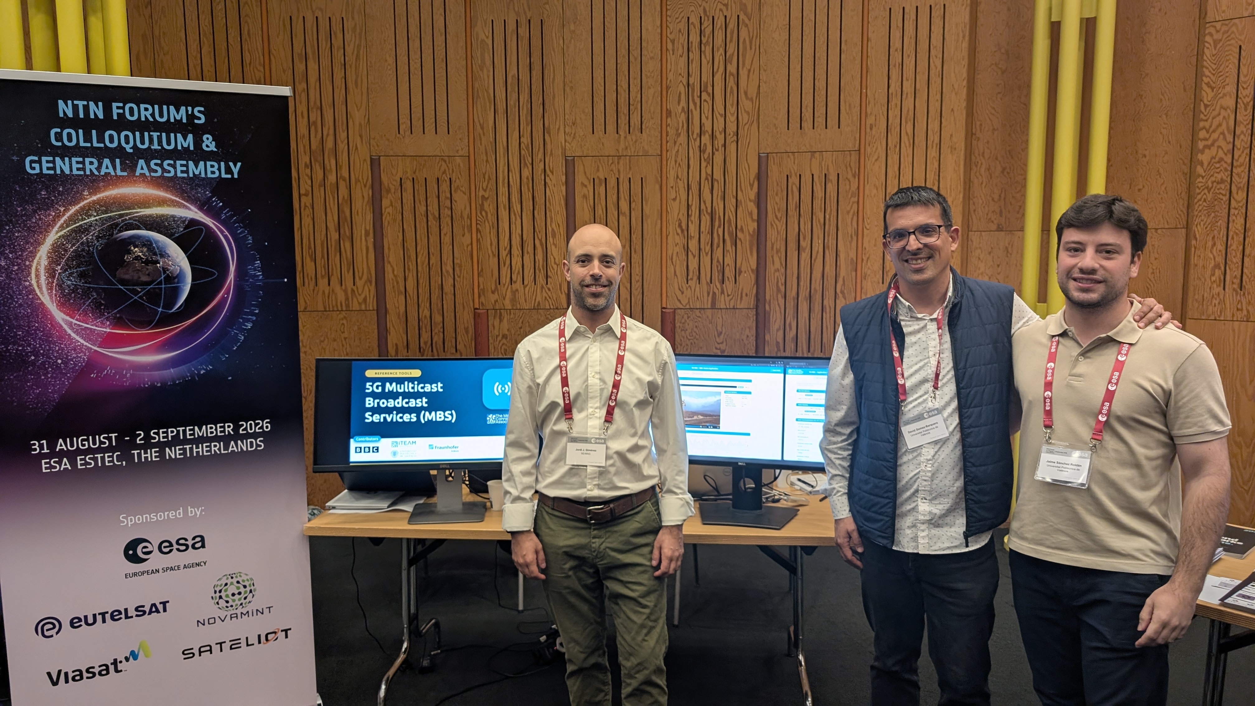 5G-MAG members at the 5G Multicast Broadcast Services (MBS) reference tools demo stand, next to the NTN Forum's Colloquium & General Assembly event banner, ESA/ESTEC, 31 August - 2 September 2026